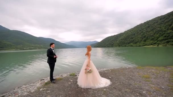 Verliefde paar op de achtergrond van de rivier en de bergen — Stockvideo