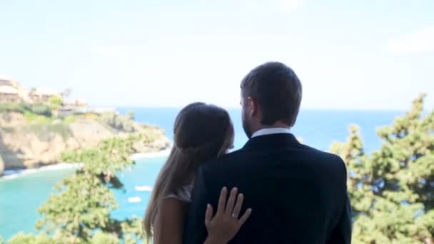 Novia y novio felices en la orilla del mar el día de su boda. El concepto de una vida familiar feliz — Vídeos de Stock