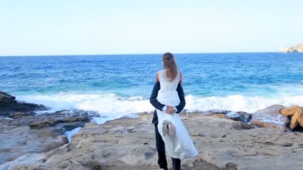 Novia y novio felices en la orilla del mar el día de su boda. El concepto de una vida familiar feliz — Vídeos de Stock