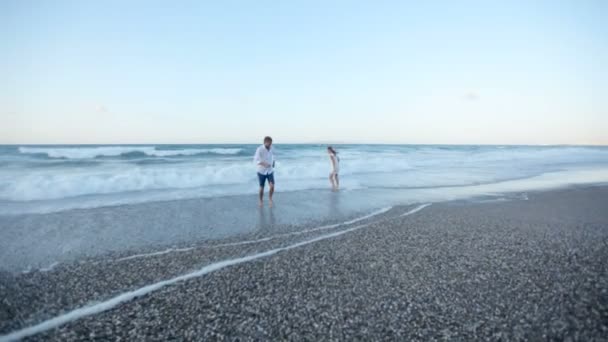 En kille och en tjej är att ha kul på stranden — Stockvideo