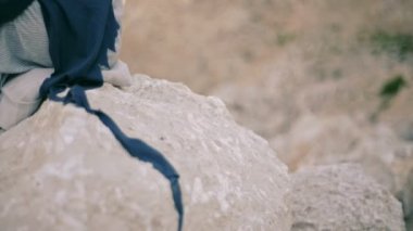 bir rock Dağları nın arka planda üzgün genç kadın oturur