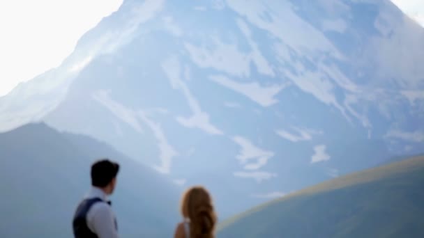 Boda. recién casados contra el telón de fondo de las majestuosas montañas — Vídeos de Stock