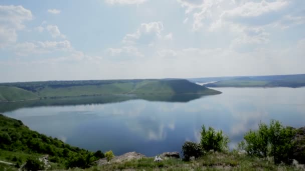 Panoramic view of the wide river with steep banks, forest, blue sky with white clouds reflected in the water. Aerial view — Stock Video