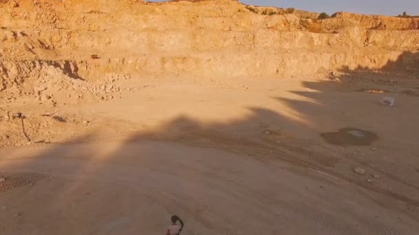 Une jeune femme marche le long du sable jaune parmi les montagnes jaunes pieds nus jusqu'au piano blanc. Vue aérienne. Parcelle surréaliste . — Video