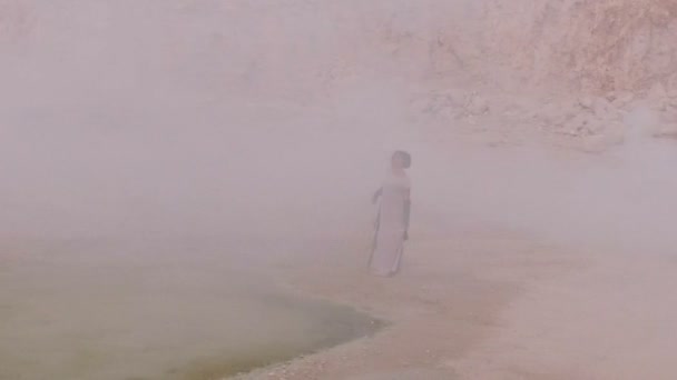 Hermosa mujer sobre un fondo de humo blanco, piedras y montañas. Fantásticamente hermosa historia. Vista aérea . — Vídeos de Stock