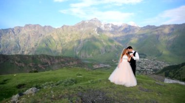 Gelin ve damat bir muhteşem dağ manzara arka planda. Gürcistan. Kazbegi. Photosession düğün