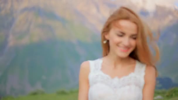 Mooie vrolijke bruid tegen de achtergrond van bergen. Trouwdag — Stockvideo