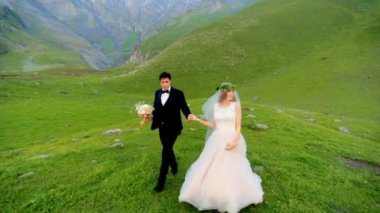 Aşık yeni evliler karşı güzel dağlar zemin çayır akşamları yürümek