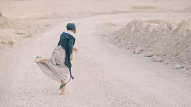 Щаслива дівчина босоніж танцює на дні піщаної ями — стокове відео
