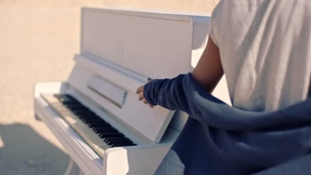 山と不毛の地の白いピアノを背景に美しく、夢のような若い女性。シュル レアリスム。ミラージュ — ストック動画