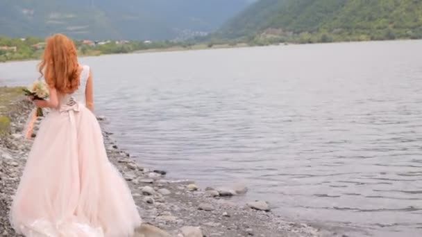 Hermosa novia en el fondo de las montañas y el río. Día de la boda — Vídeos de Stock