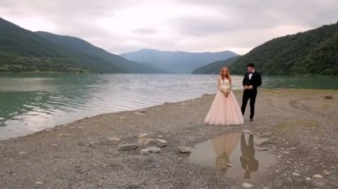 Mutlu gelin ve damat bir nehir arka plan üzerinde. Yeni evliler su güzel yansıması