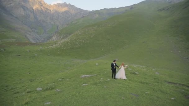 Paseo romántico inolvidable de los novios en el día de su boda entre las montañas más bellas de Georgia — Vídeos de Stock