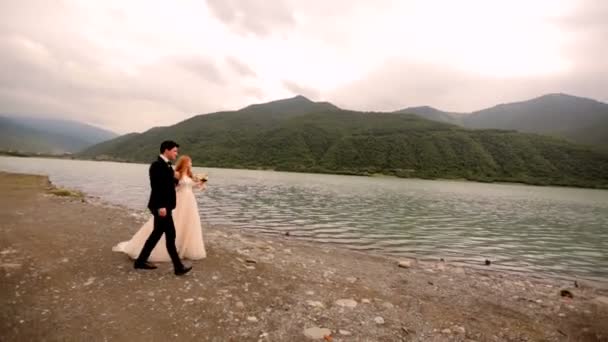 Verliefde paar op de achtergrond van de rivier en de bergen — Stockvideo