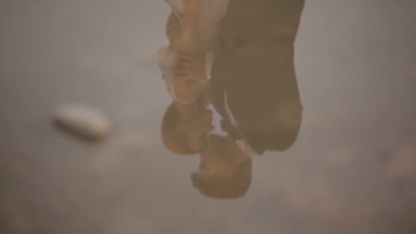Glückliche Braut und Bräutigam vor dem Hintergrund eines Flusses. schöne Reflexion des Brautpaares im Wasser — Stockvideo