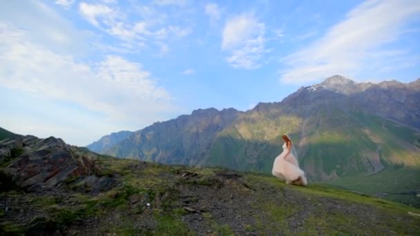Düğün günü. Güzel bir ihale gelinlik gelin çarpıcı bir dağ manzarası arka planı var. Gürcistan. Kazbegi. — Stok video