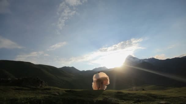 Boldog menyasszony boldogan spinning a naplementét a hegyek a háttérben — Stock videók