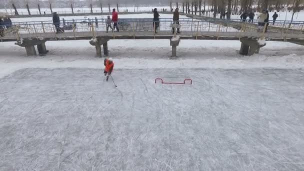 Widok z lotu ptaka. mężczyzn gry w hokeja na zamarzniętym jeziorze w parku miejskim. Zimowe zabawy dla rodzin z dziećmi. Hokej na lodzie. — Wideo stockowe