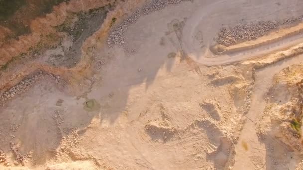 Surreal picture. Young bosy1 man plays the piano in an abandoned territory sandy quarry. Aerial view. — Stock Video