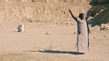 Garip bir rüya. Bir arka plan dağlar ve taşlar ve beyaz piyano şık giysiler içinde güzel ve genç birbayan. Sürrealizm. Serap