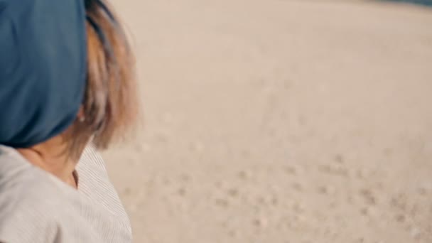 Een prachtige en dromerige jonge vrouw zit op het gele zand in de buurt van de piano. Onwerkelijk plot. Close-up. — Stockvideo