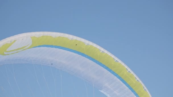 Зимові види спорту. Яскраві жовті парашут проти синього неба — стокове відео
