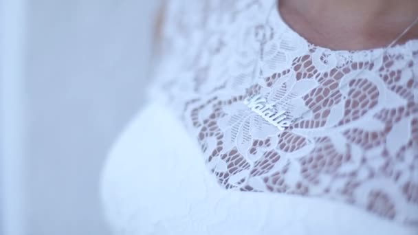 Meisje met een keurige manicure in een witte jurk past de keten — Stockvideo