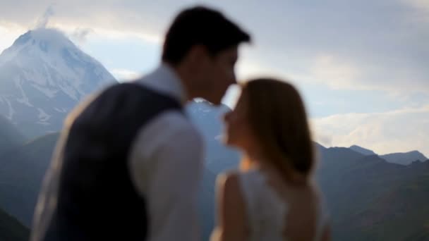 Glad flicka och pojke med ömhet och kärlek ser på varandra på kvällen i bergen. Kazbek. Georgien — Stockvideo