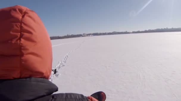 El tipo monta una moto de nieve en el fondo de una ciudad de invierno. Vista superior desde la cabeza en el salpicadero — Vídeos de Stock