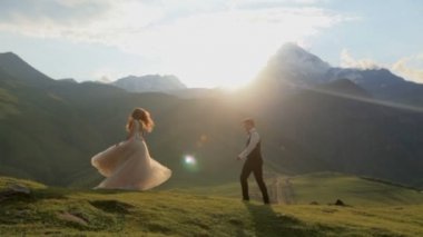 Bir adam ve gün batımında dağlarda güzel elbiseli bir kız güzel video