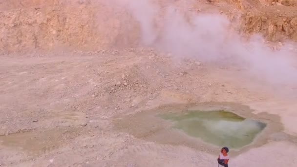 Mujer joven y elegante camina hacia el lago en las montañas contra un humo blanco. Vista aérea . — Vídeos de Stock