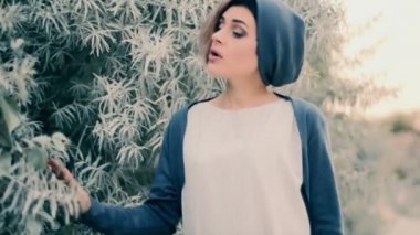 Güzel kız bir yeşil ağaç yakınındaki bir şarkı söylerken