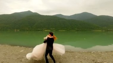 Romantik tarih gelin ve damat pitoresk dağlar arka plan üzerinde Nehri yakınında