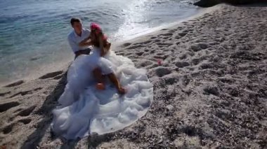 Sürrealizm. Gelin damat ile muhteşem elbise giymiş olan deniz kum üzerinde