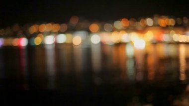 Parlak ışıkları karanlık deniz suyu tekneler ile iskelede yansıtılır. bokeh.