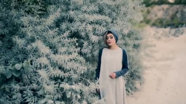 Красивая девушка поет песню возле зеленого дерева — стоковое видео