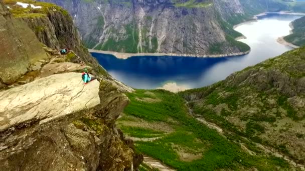 Noorwegen. meisje op de rand van de rots van de Trolltunga. antenne vie. — Stockvideo