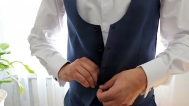 Beyaz gömlekli bir adam bir yelek giyer. Düğün günü