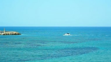 Deniz feneri ile güzel bir adaya mavi denizde yüzen zevk teknesi. Yunanistan 'da harika bir tatil kavramı.