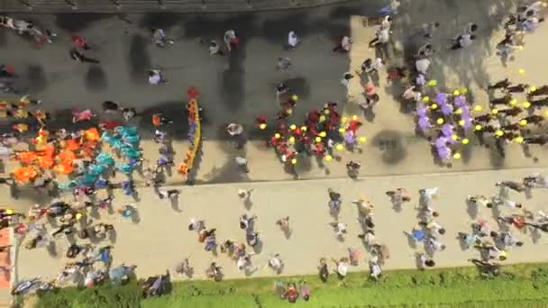 Luchtfoto van de plechtige parade van dansgroepen marcheren langs de belangrijkste straten van de stad langs de dijk naar het meer. Ternopil Oekraïne. Het concept van interessante vrijetijdsbesteding — Stockvideo