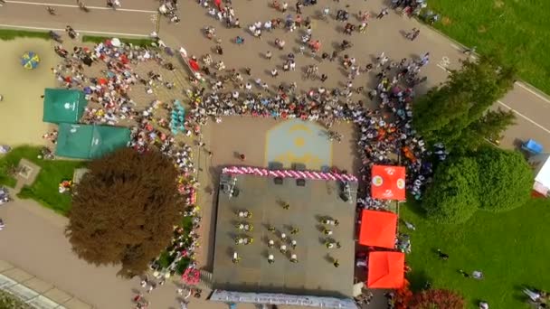 Vuelo de vista aérea sobre el parque y hermoso lago azul en el centro de la ciudad. Festival de danza en el muelle del lago Ternopil. Ucrania. El concepto de unas vacaciones de verano interesantes — Vídeo de stock