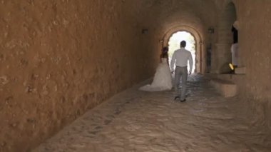 Genç bir adam sokağa kasvetli bir kaleden muhteşem bir elbise içinde güzel bir kız yol açar