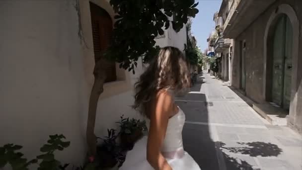 Novia gentil, encantadora, dulce en un vestido elegante en las estrechas calles del casco antiguo . — Vídeos de Stock