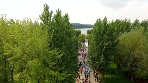 Dans gruplarının geçit törenine katılanlarla birlikte sütunun havadan görünümü şehir parkına giriyor. Ternopil Ukrayna. — Stok video