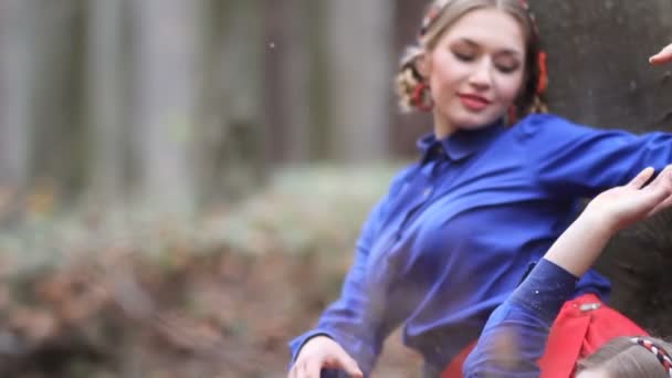 Две симпатичные девушки-близнецы гуляют по осеннему лесу — стоковое видео