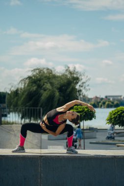 Göl kenarındaki spor sahasında egzersiz ve sicim yapan bir kız.