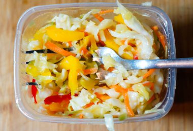 İçinde çatal, lahana biber ve havuç olan bir kutuda salata, sağlıklı vitamin salatası.