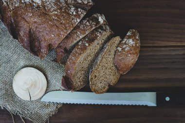 Taze pişmiş çavdar ekmeği, somun bıçağıyla ahşap bir masada, düz yatıyordu.