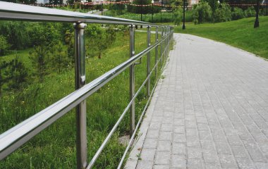 Güneşli bir yaz gününde parktaki metal korkuluklar.