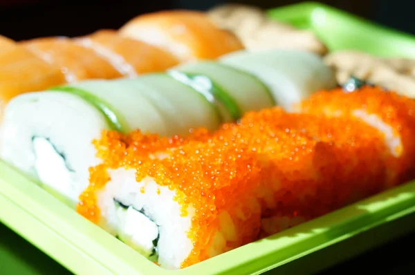 sushi rolls close-up in a plastic bowl, food home to order